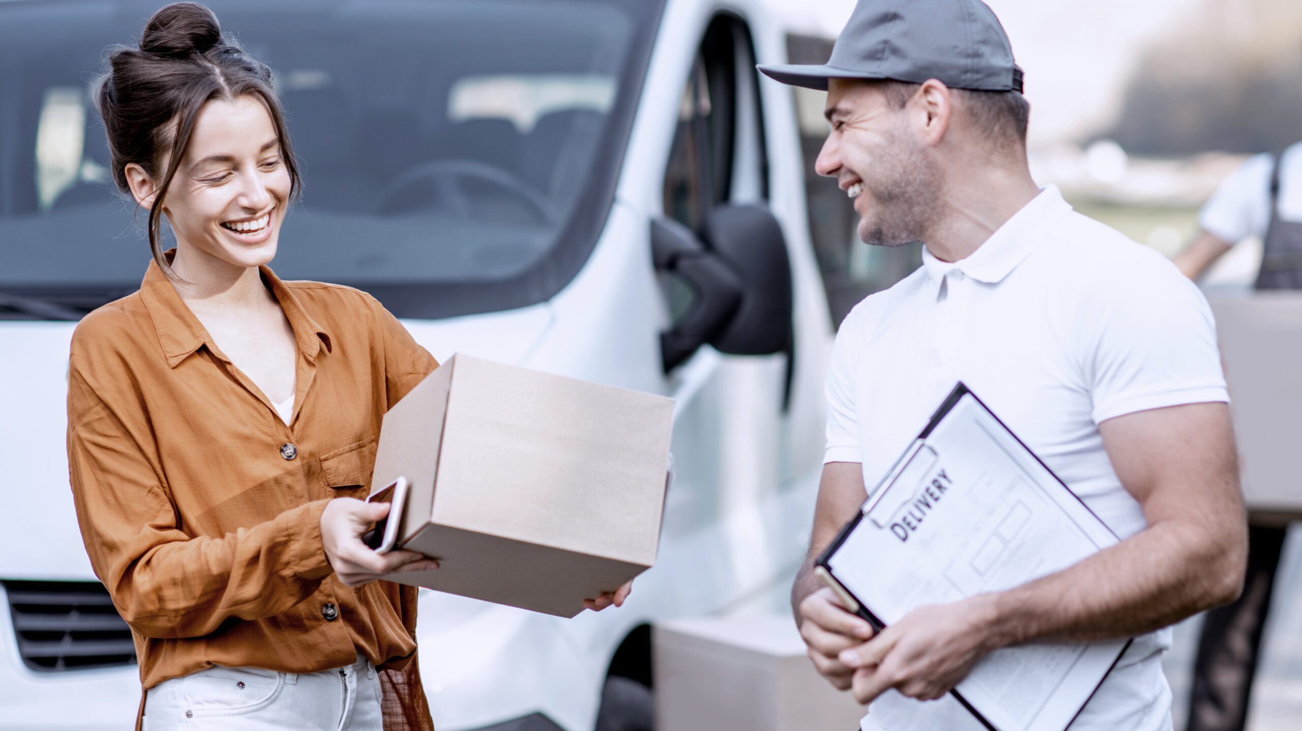 Courier handing parcel to smiling customer during same-day delivery in Birmingham