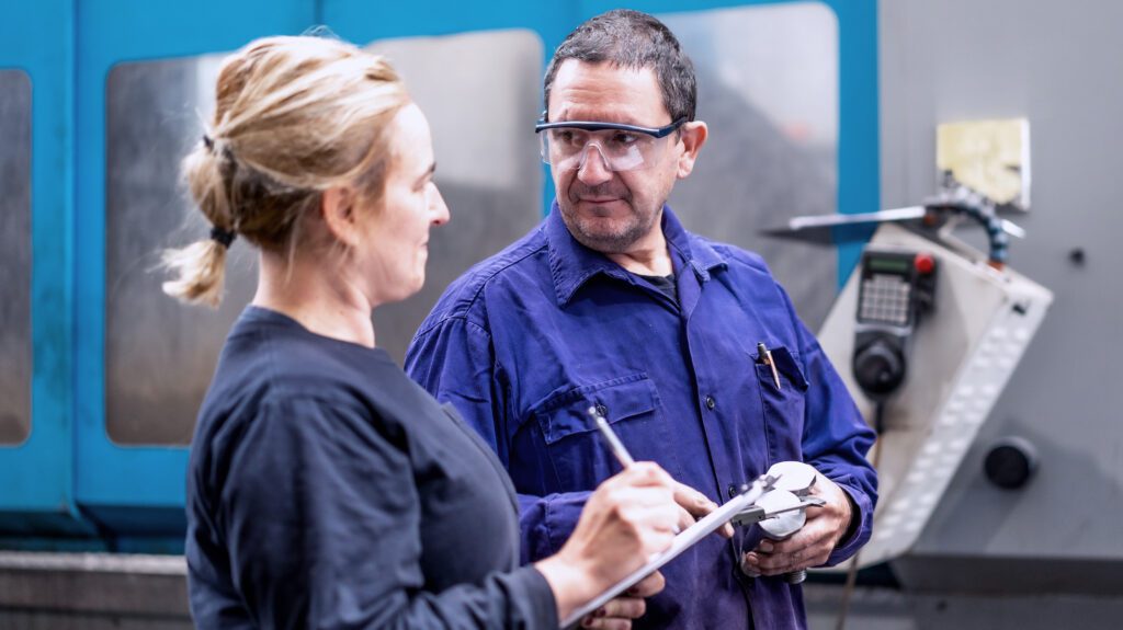 wo engineers discussing technical details in manufacturing facility